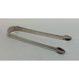 A pair of Georgian bright cut silver sugar tongs w