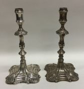 A pair of Georgian cast silver taper sticks with s