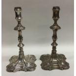 A pair of Georgian cast silver taper sticks with s