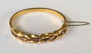 A ruby and diamond hinged bangle with concealed cl