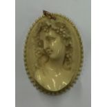 A large oval ivory cameo of a lady in high relief