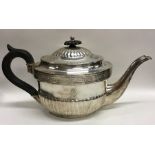 A Georgian silver half fluted teapot decorated wit
