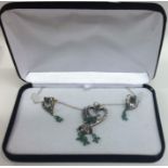 A boxed set of emerald mounted jewellery on fine l