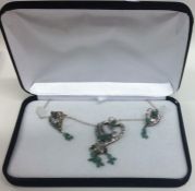 A boxed set of emerald mounted jewellery on fine l