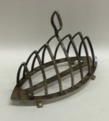 An unusual silver canoe shaped toast rack on brack