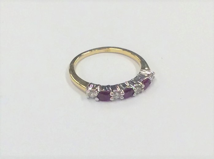 A ruby and diamond seven stone ring in 18 carat mo