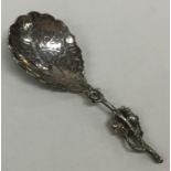 An unusual silver caddy spoon decorated with flowe