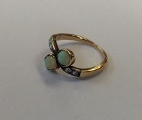 An opal and rose diamond two stone crossover ring.