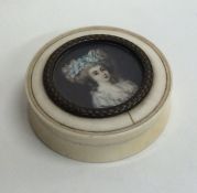 A circular ivory pill box with central miniature.