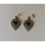 A pair of diamond and sapphire heart shaped earrin