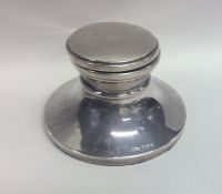 A silver circular capstan shaped inkwell with hing