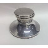 A silver circular capstan shaped inkwell with hing