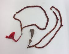 Two strings of amber beads mounted with tassels. A