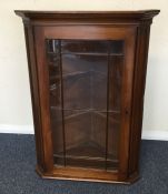 An oak corner cupboard with bevelled glass. Est. £