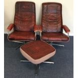 A pair of retro leather mounted swivel chairs toge