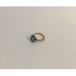 A 9 carat and blue stone ring in claw mount. Appro