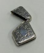 A silver hinged top vesta case with diagonal openi