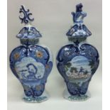 A pair of tall Delft vases and covers decorated in