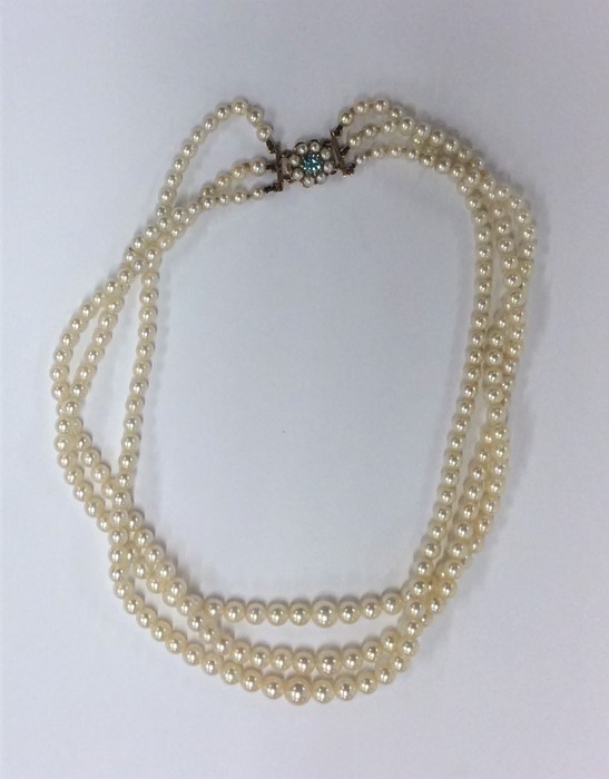 A triple string of pearl beads with pearl and zirc