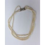 A triple string of pearl beads with pearl and zirc