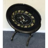 An oval hinged top papier-mâché table. Est. £25 -