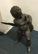 A large brass model of a child clutching a goose.