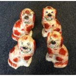 Two pairs of Staffordshire dogs with red coats in