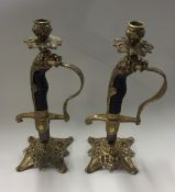 A pair of novelty brass mounted candlesticks in th