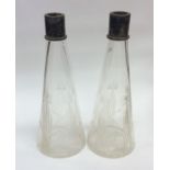 A pair of tapering glass decanters with plated top