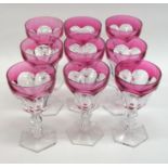 A set of ten cranberry glass wine glasses on hexag