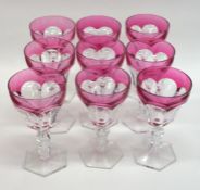 A set of ten cranberry glass wine glasses on hexag