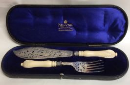 A pair of silver plated fish servers with turned i