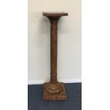A wooden jardiniere stand on tapering pedestal bas