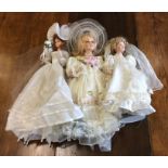 Three dressed porcelain headed dolls in bridal wea