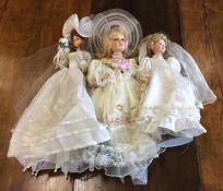 Three dressed porcelain headed dolls in bridal wea