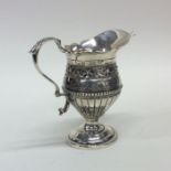 A Victorian half fluted silver cream jug on scroll