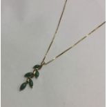 A heavy gold and jade pendant on fine link chain.