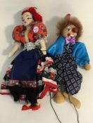 A wooden puppet of a clown together with a doll in
