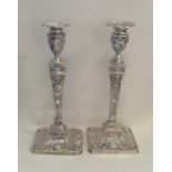 A tall matched pair of large silver candlesticks w