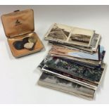 A box containing old postcards, badges etc. Est. £