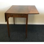 A mahogany two flap Pembroke table on tapering sup