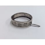 A Continental silver hinged bangle with floral dec