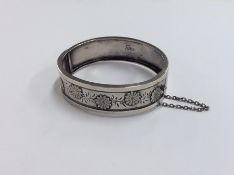 A Continental silver hinged bangle with floral dec