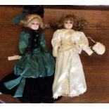 Two dressed porcelain headed dolls; one in green g