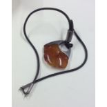 A silver and amber pendant on leather strap. Appro