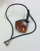 A silver and amber pendant on leather strap. Appro