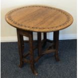 An Edwardian carved top drop leaf occasional table