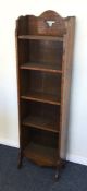 A tall oak slim bookcase. Est. £25 - £35.