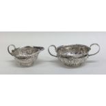An unusual silver cream and sugar bowl inset with