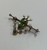 A peridot and pearl brooch in the form of a shield